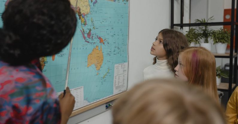 Learning - Teacher teaching students about Geography using a Map